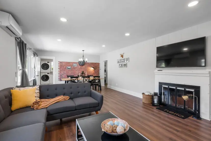 Living room with a charcoal sectional and a white mantel fireplace