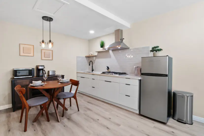 Compact white kitchen and a round dining table