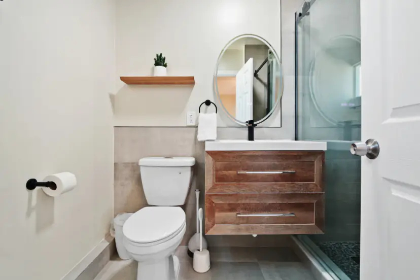 Bathroom with a wood vanity and a round mirror