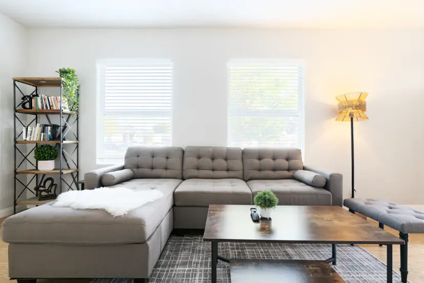 Living room with a tufted sectional and a bookshelf