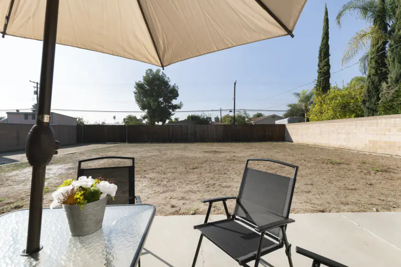 Patio table with an umbrella facing the large backyard