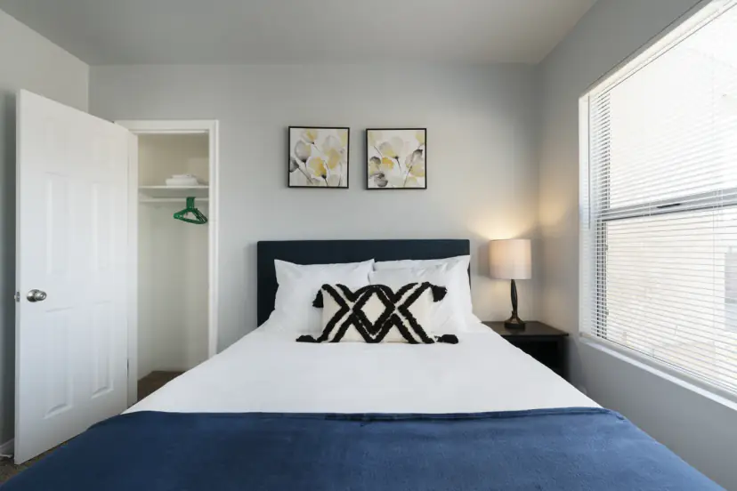 Queen bed with a navy throw and floral prints
