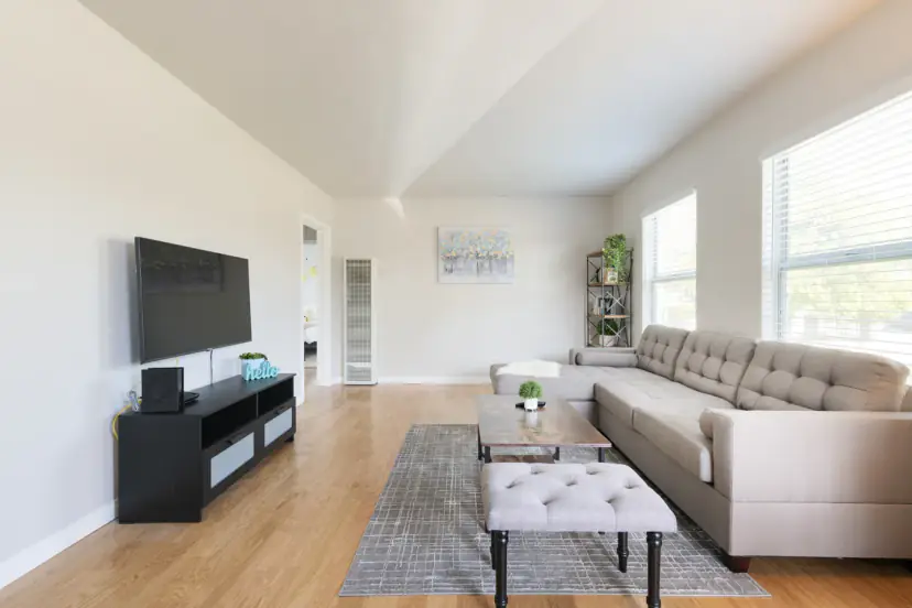 Living room with a tufted sectional and a wall TV