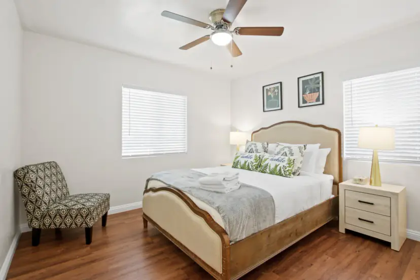Bedroom with an upholstered bed and a ceiling fan