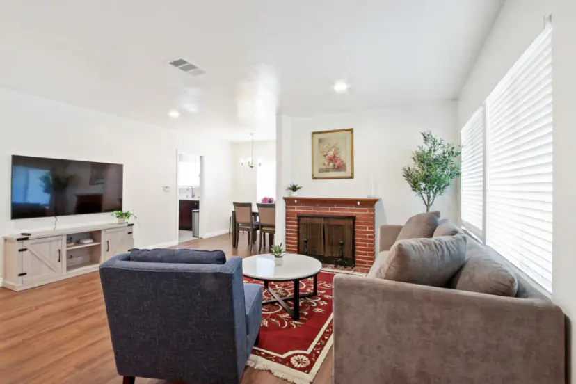 Living room with a brick fireplace and a TV console