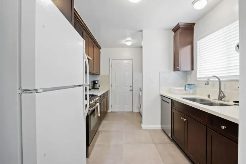 Galley kitchen with a white fridge