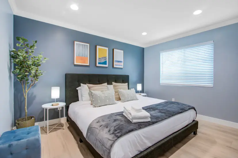 King bed with a tufted headboard and a blue accent wall