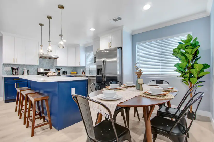 Dining table with the blue kitchen island and stools
