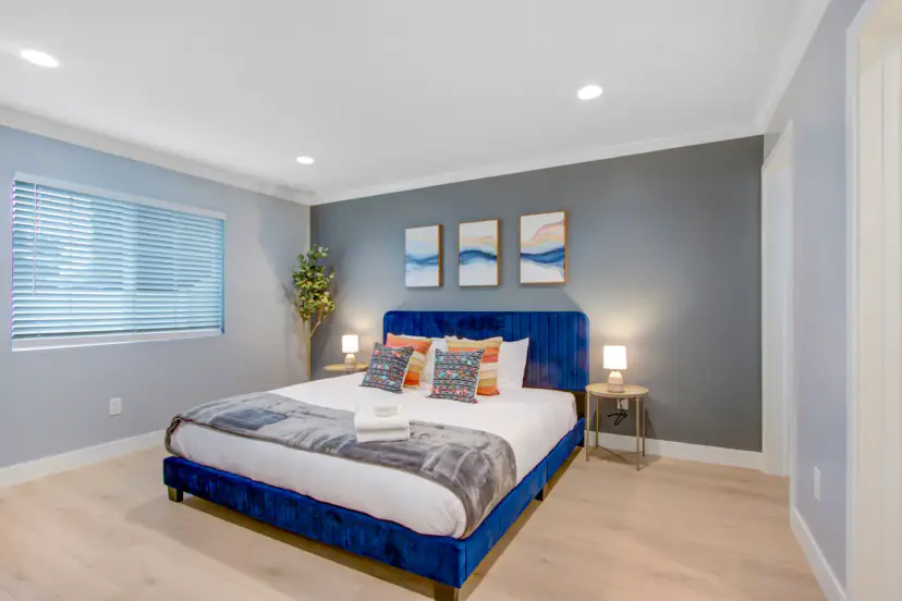Blue velvet bed with an abstract triptych