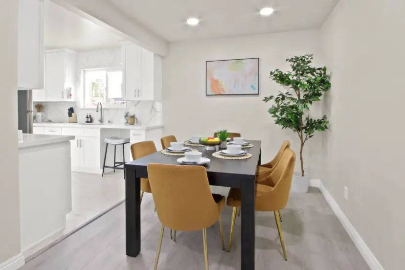 Dining table with velvet chairs by the white kitchen