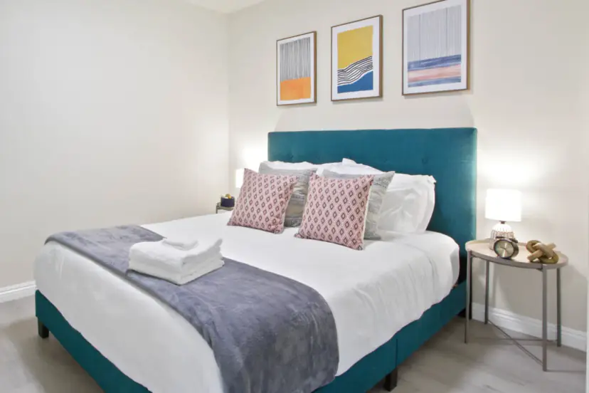 Teal upholstered bed with colourful abstract prints