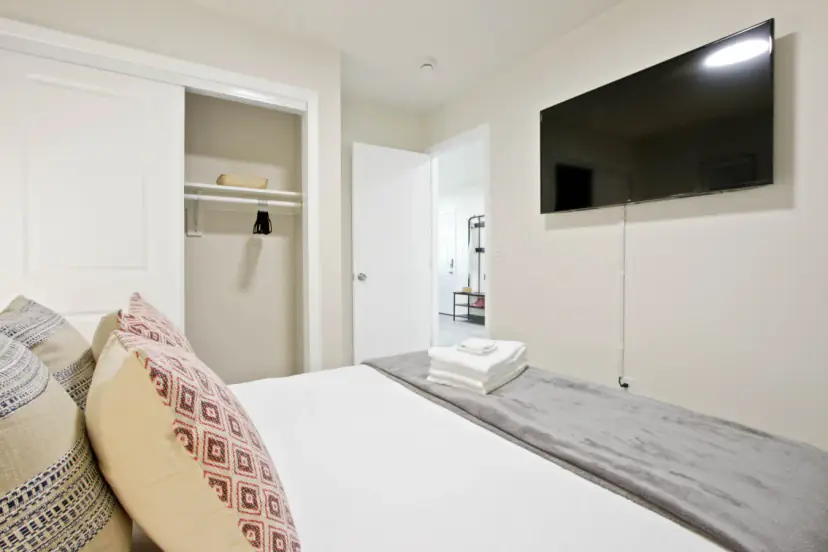Bedroom with a wall TV and a sliding closet