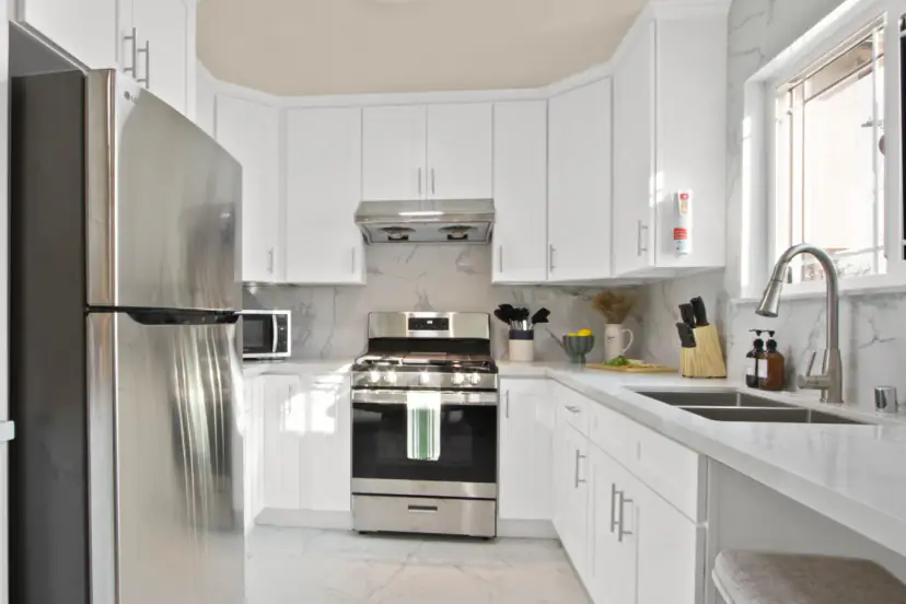 White kitchen with a stainless range and double sink