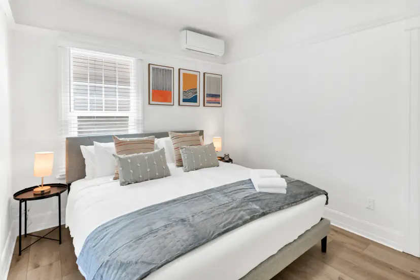 King bed under a window with three prints