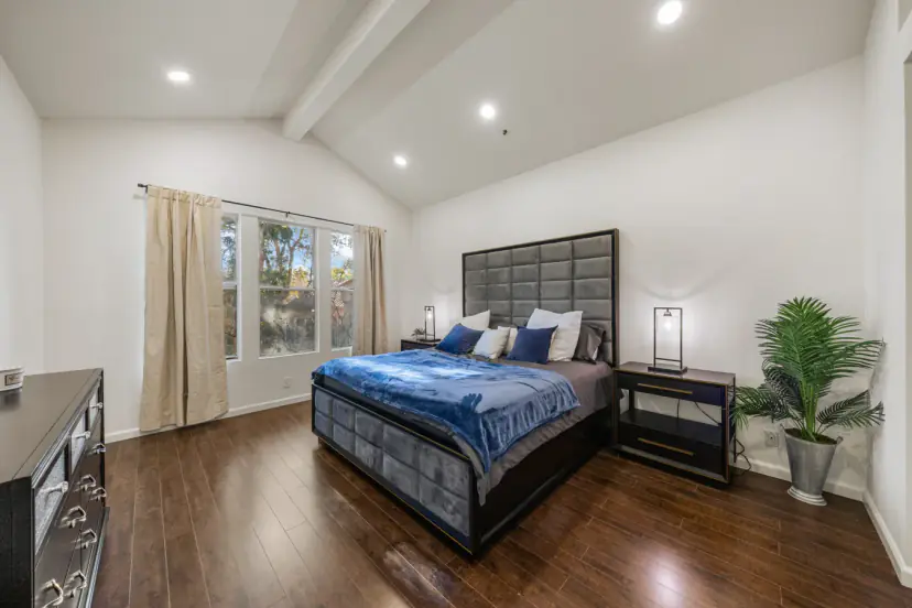 Primary bedroom with a tall tufted headboard