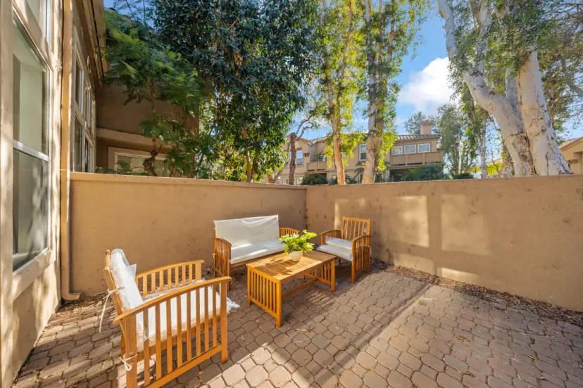 Walled patio with a wood lounge set