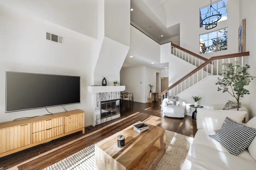 Living room with a wall TV and a marble fireplace