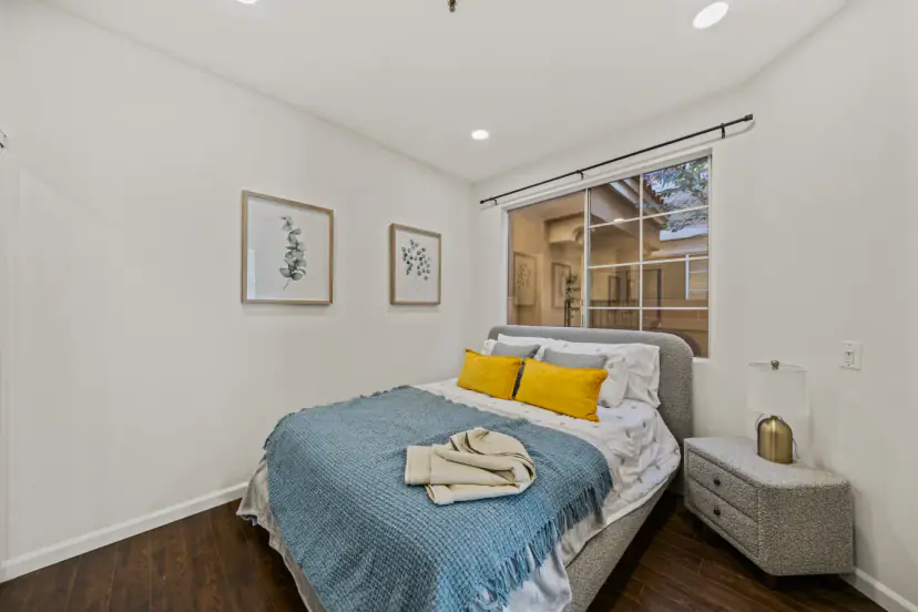 Bedroom with a grey bed and mustard pillows