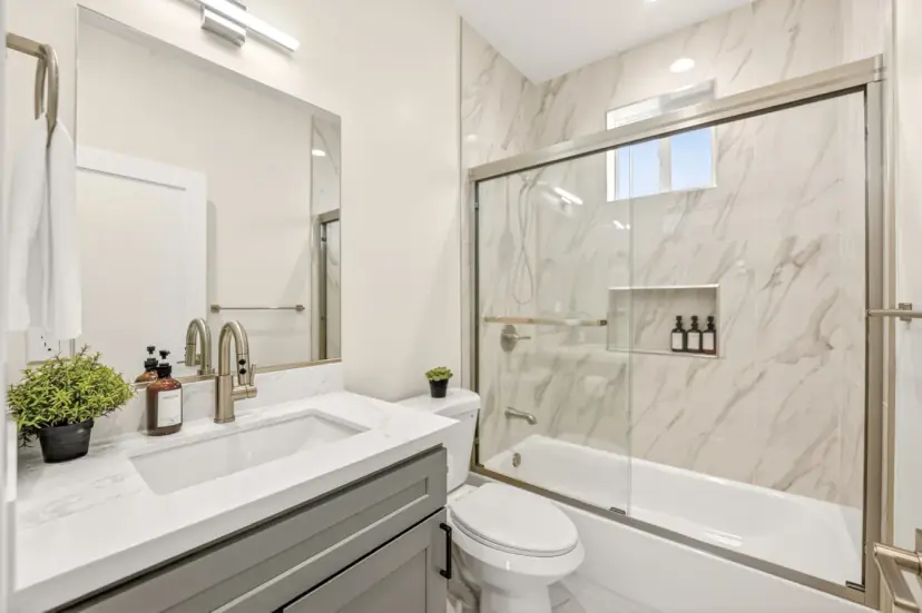 Bathroom with a grey vanity and a marble-look tub-shower