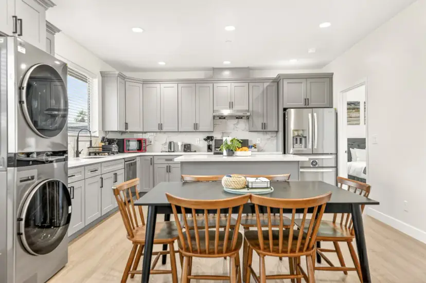 Dining table beside the kitchen and a stacked washer and dryer