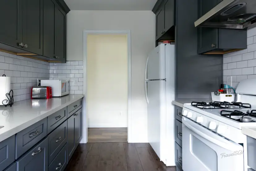 Galley kitchen with charcoal cabinets and a gas range