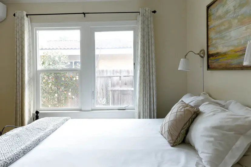 Bed by a window with wall lamps