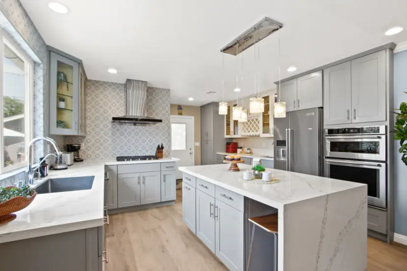 Grey shaker kitchen with a quartz waterfall island and stainless appliances