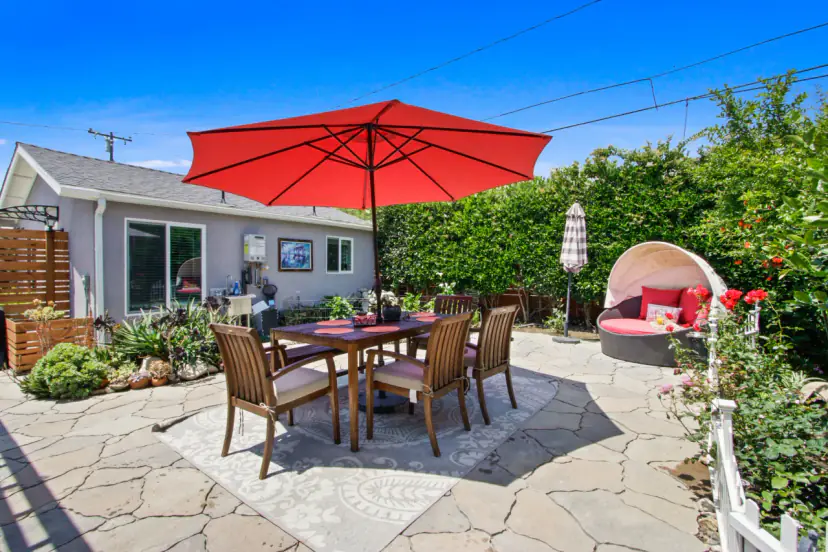 Stone patio with a dining table under a red umbrella