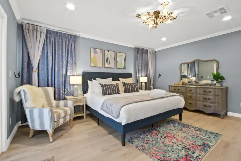 Bedroom with a navy upholstered bed and a striped armchair