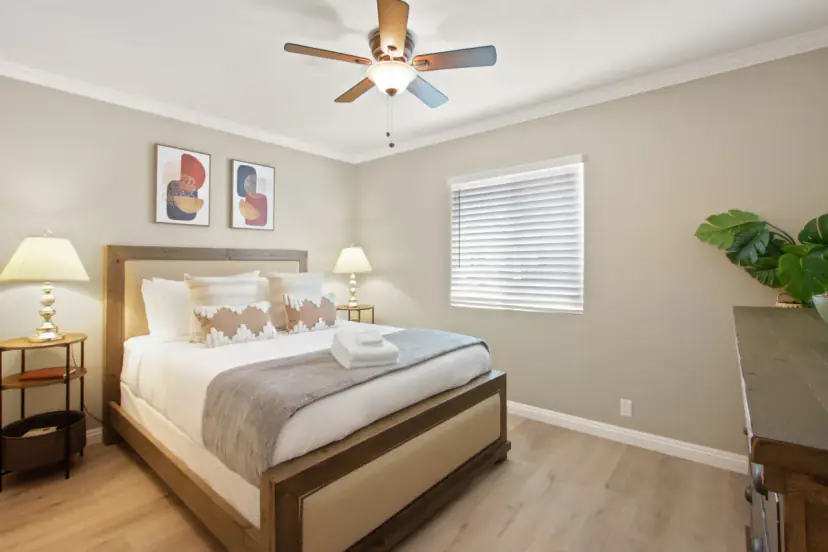 Bedroom with an upholstered bed and a ceiling fan