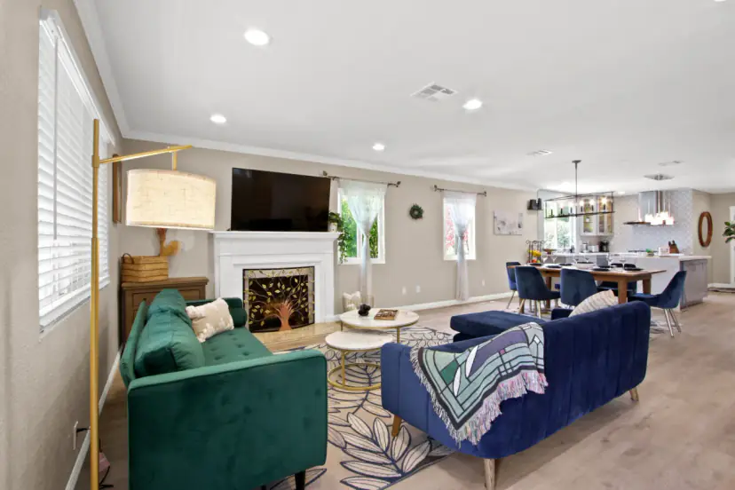 Living room with a green sofa, a fireplace and a wall TV