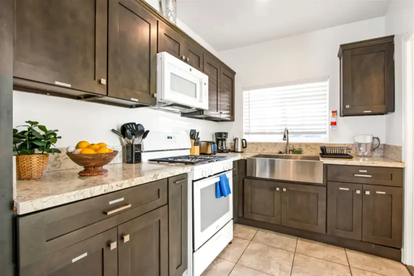 Kitchen with espresso cabinets, granite counters and a gas range