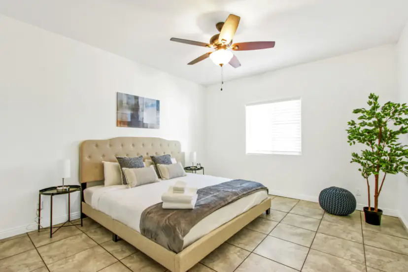 Bedroom with an upholstered king bed and a ceiling fan