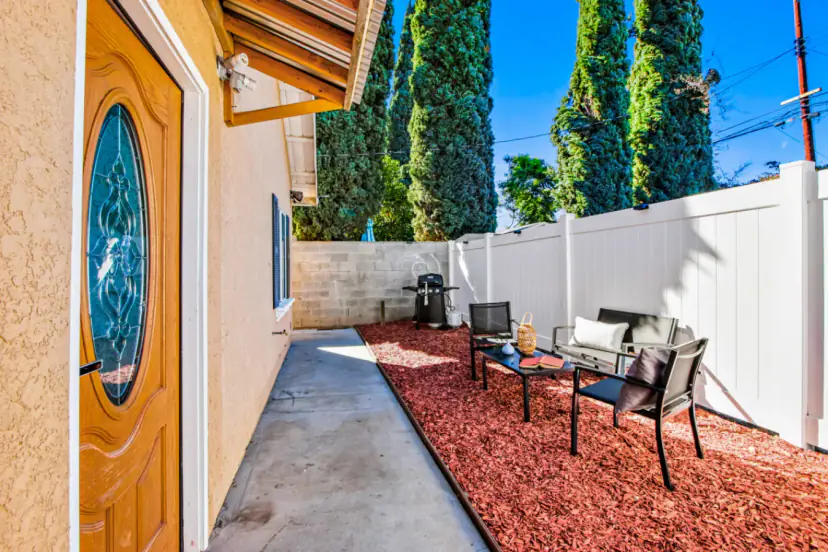 Fenced side yard with patio chairs and a grill