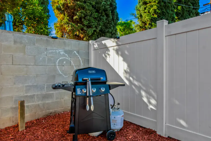 Gas grill in the fenced yard