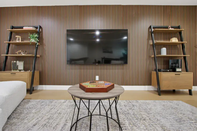 Slatted wood TV wall with shelves and a board game on the coffee table