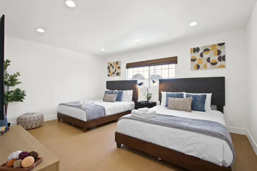Bedroom with two beds and abstract wall art