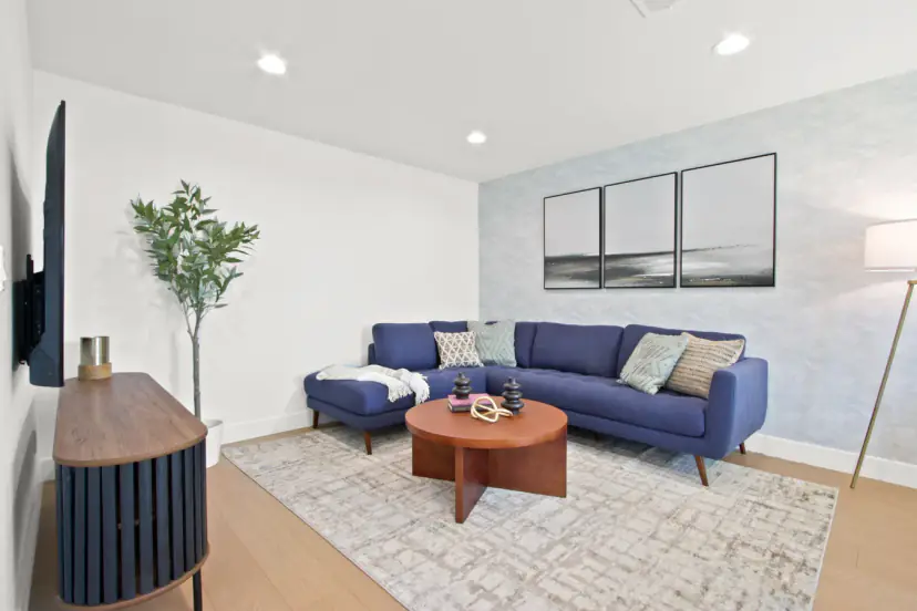 Living room with a navy sectional and a round wood coffee table