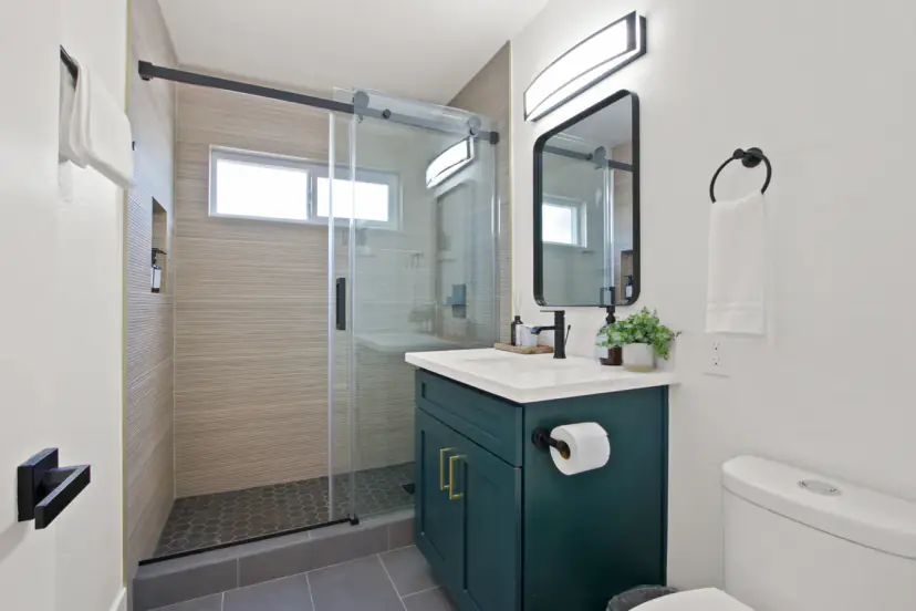 Bathroom with a glass shower and a green vanity