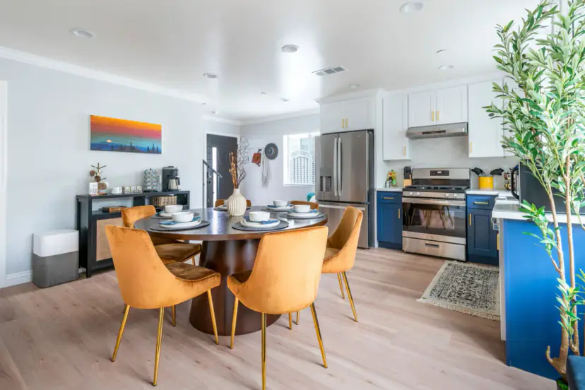 Open kitchen and dining room with a round table and mustard velvet chairs