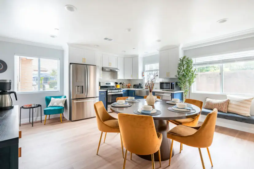 Dining table with mustard velvet chairs and a window seat beyond