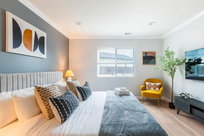 Bedroom with a grey tufted bed and two bedside lamps
