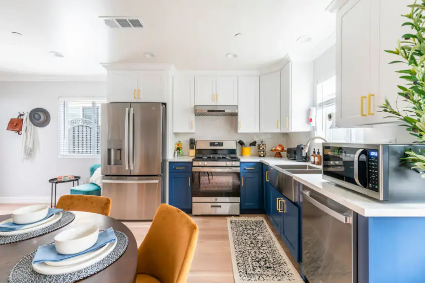 Kitchen with a stainless fridge, navy cabinets and a gas range