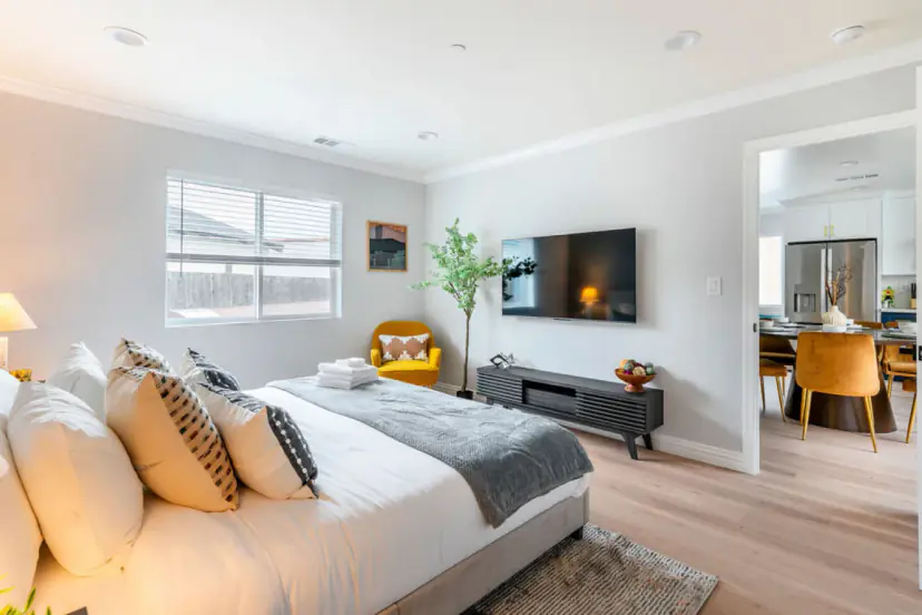 Bedroom with a TV and an open door to the dining room