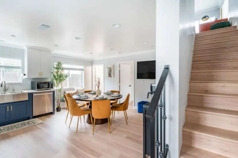 Stairs beside the open dining room and kitchen