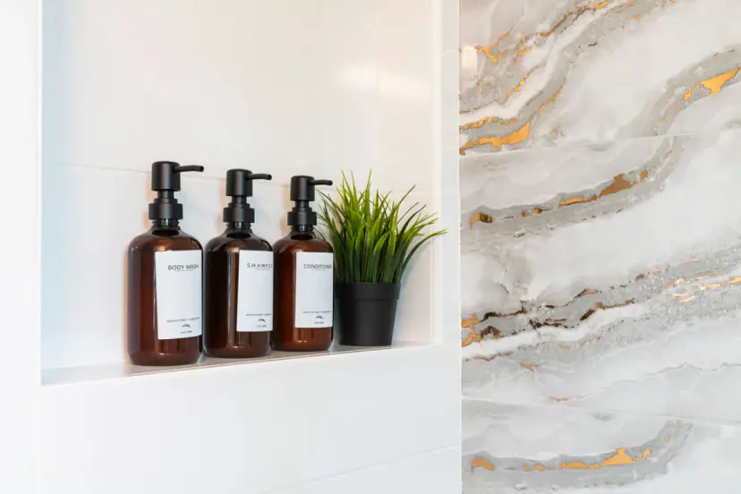 Shower niche with amber bottles against marble-look tile