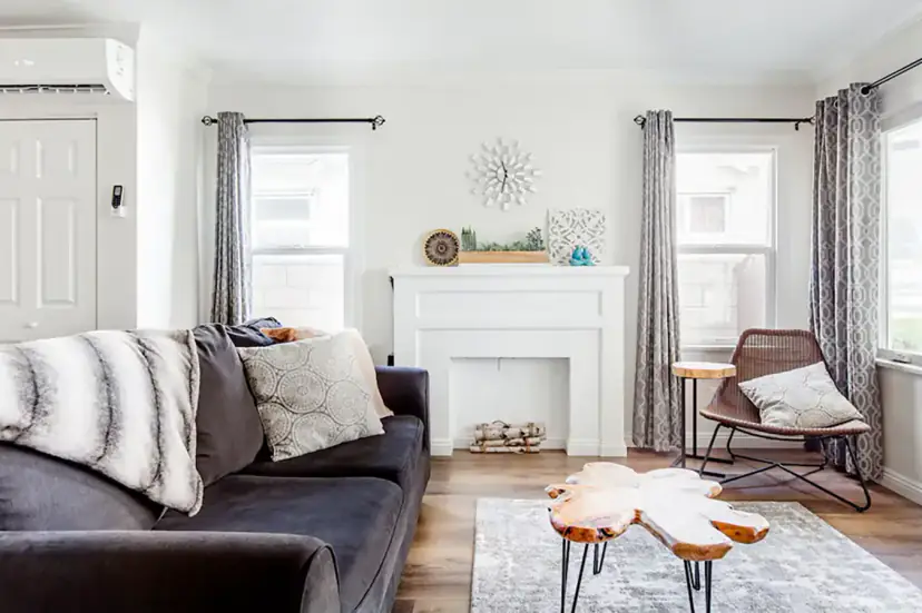 Living room with a grey sofa, a live-edge table and a white mantel