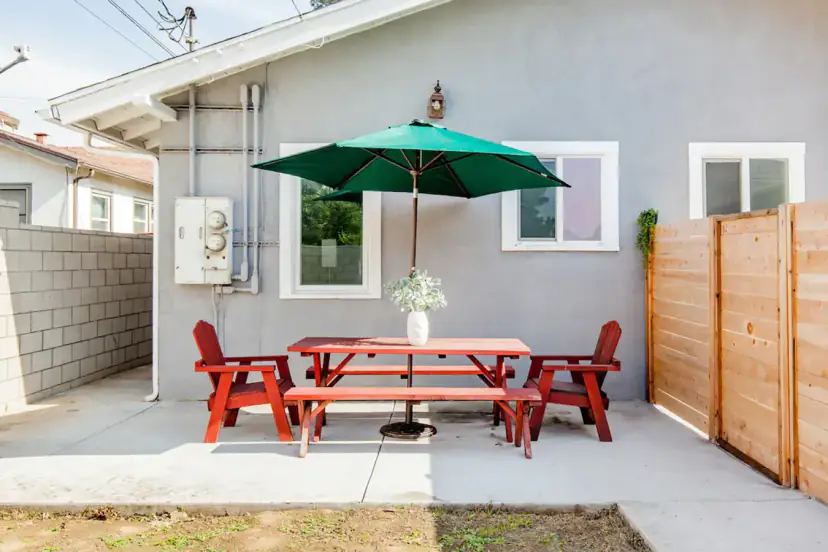 Back patio with a red picnic set under a green umbrella