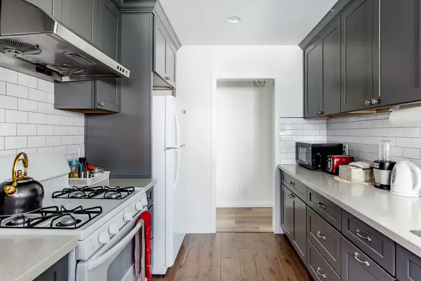 Galley kitchen with grey cabinets and a gas range