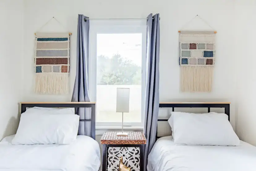 Two twin beds with woven wall hangings